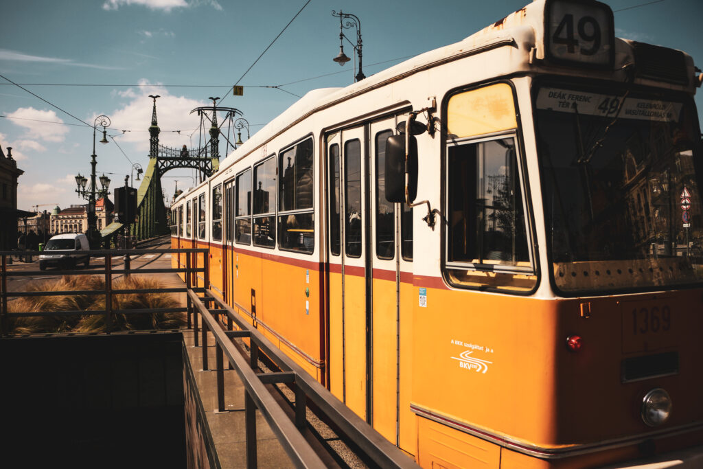 A classic yellow tram crossing the iconic Liberty Bridge in Budapest, showcasing urban transit.